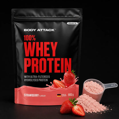 Body Attack 100% Whey Protein powder in Strawberry Flavour, 900g pouch, shown with a scoop of the light pink powder and fresh strawberries on a black background.
