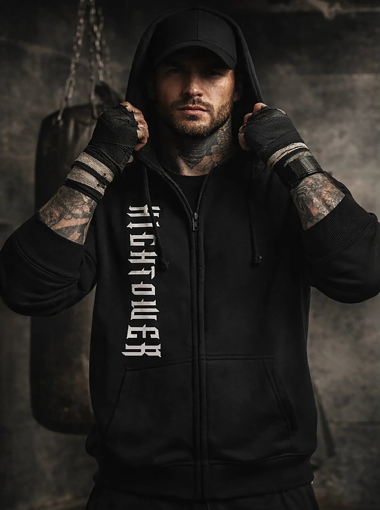 Man wearing a black hoodie with 'Righteous' text, standing against a dark background.