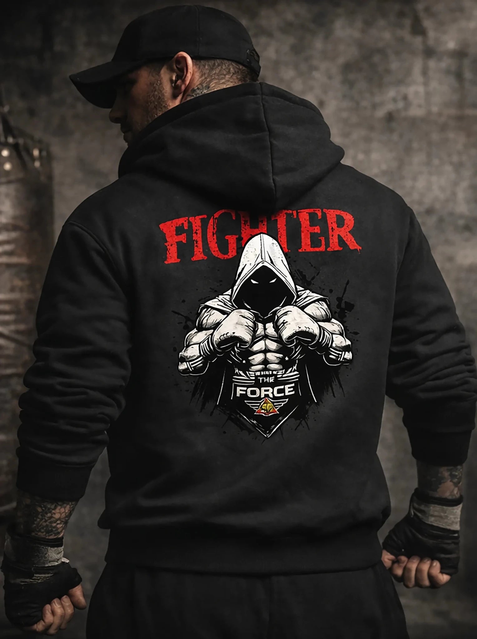 Person wearing a black hoodie with 'FIGHTER' text and graphic design on the back.